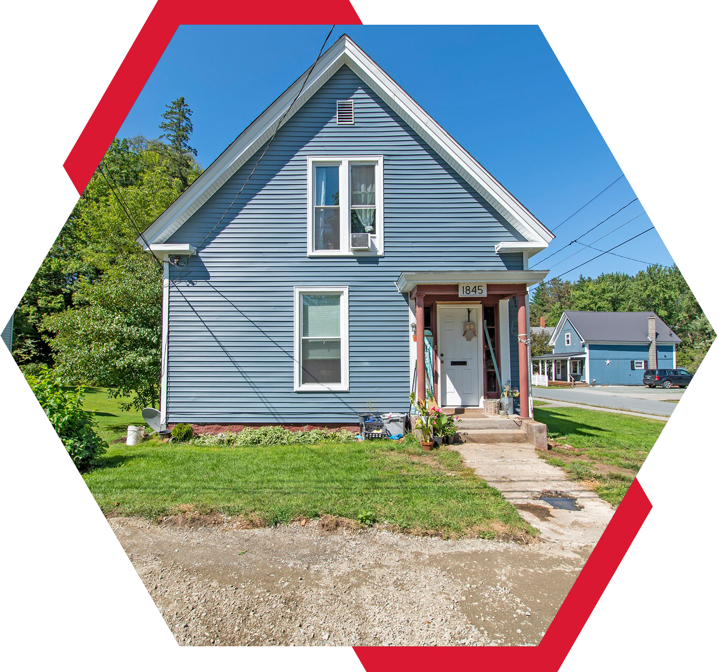 A blue house with red trim and grass around it.