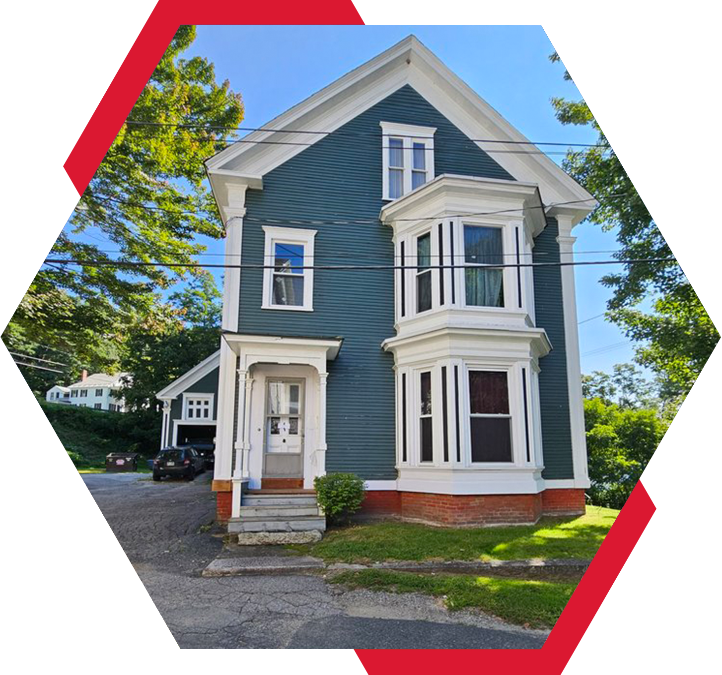 A blue house with red trim and white windows.