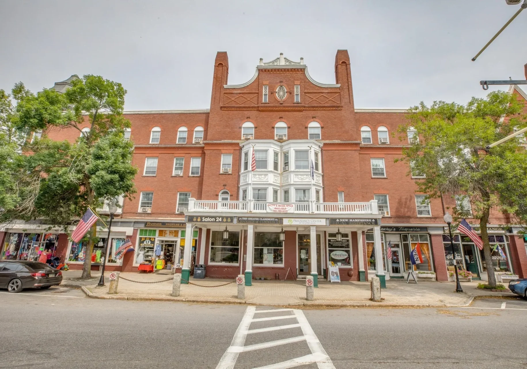 A large brick building with many windows on the side of it.