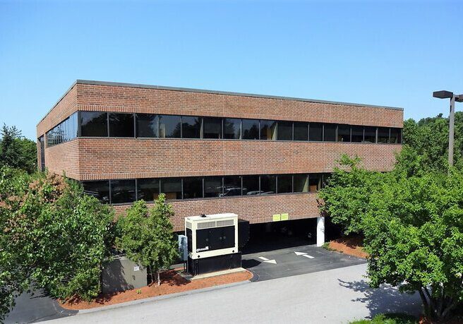 A large brick building with trees in front of it.